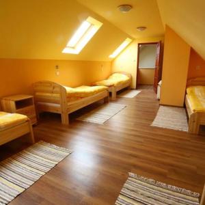 una camera con 4 letti in una camera con pavimenti in legno di Tiszavirág Vendégház a Tiszabábolna