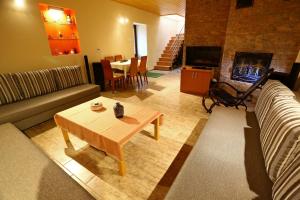 a living room with a couch and a table and a fireplace at Tiszavirág Vendégház in Tiszabábolna