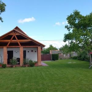 una pequeña casa de ladrillo con un patio de hierba en Tiszavirág Vendégház, en Tiszabábolna