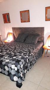 Schlafzimmer mit einem Bett mit einer schwarzen und weißen Bettdecke in der Unterkunft Bonheur à la résidence Savane in Le Gosier