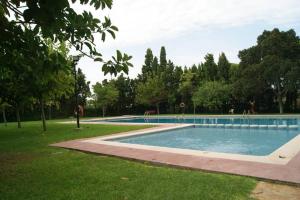 une grande piscine dans un parc arboré dans l'établissement mar y golf en muchavista, à Alicante