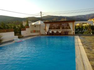 a swimming pool in a backyard with a house at Villa Costa Hydra in Plépi