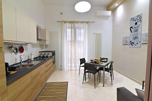 una cucina e una sala da pranzo con tavolo e sedie di Gemini Suite a Salerno