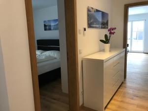 テガーンゼーにあるLea am See - Bio Design Appartementの鏡とドレッサー付きの部屋、ベッドルーム1室が備わります。