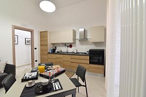 una cucina e un soggiorno con tavolo e sedie di Gemini Suite a Salerno Altre 16 foto