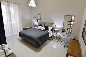 サレルノにあるGemini Suiteのベッドルーム1室(ベッド1台、椅子付)