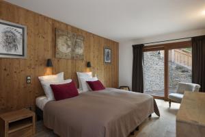 a bedroom with a large bed and a window at Chalet Zebra in Méribel