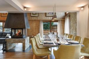 a dining room with a long table and a fireplace at Chalet Zebra in Méribel