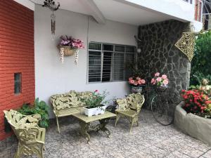 a patio with chairs and a table and flowers at Pousada Castelinho in Caldas Novas