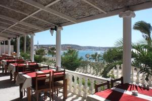 a restaurant with tables and chairs and a view of the ocean at Çeşme Farm Hotel in Çeşme