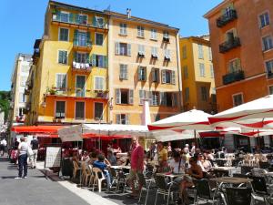 a group of people sitting at tables with umbrellas at Nice Renting - COLONNA - Best place in Nice Old Town in Nice