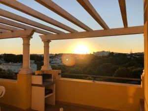 einen Blick auf den Sonnenuntergang vom Balkon eines Gebäudes in der Unterkunft Albufeira Luxury Villa in Albufeira