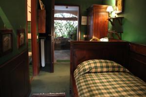 een slaapkamer met groene muren en een bed en een deuropening bij Una Franca Camere Di Charme in Biella