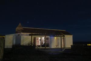 a small white house at night with the lights on at Canário do Mar - Rural Tourism in Angra do Heroísmo