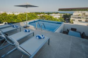 普拉亞德爾卡曼的住宿－Menesse 32 - Penthouse Con Alberca Privada Vista Al Mar By Hola，一个带桌椅的庭院和一个游泳池