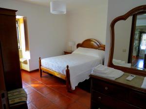 蓬蒂達巴爾卡的住宿－Quinta do Coto Moinho，一间卧室配有床、镜子和梳妆台