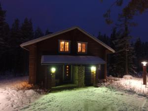 una cabina nella neve di notte di Villa Levinkajo a Levi
