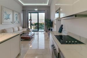 Menesse 32 - Penthouse Con Alberca Privada Vista Al Mar By Hola في بلايا ديل كارمن: مطبخ وغرفة معيشة مع أريكة وطاولة