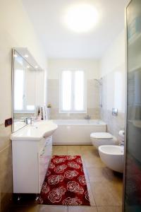 a bathroom with two sinks and a tub and a red rug at Casa Cristina in Montale +7 photos