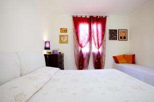 a bedroom with a bed and a window with red curtains at Casa Cristina in Montale