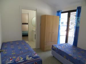 1 Schlafzimmer mit 2 Betten, einer Kommode und einer Tür in der Unterkunft Fraser Forever Orchid Beach Fraser Island in Fraser Island