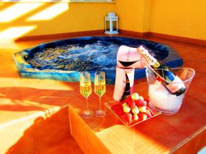 a table with two glasses of wine and a swimming pool at Tu Hogar en Verazul in Vera