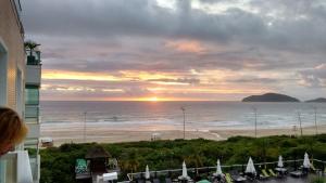 desde el balcón de un hotel con vistas a la playa al atardecer en Santinho - Frente para Mar, Pé na Areia, Dois Quartos, en Florianópolis