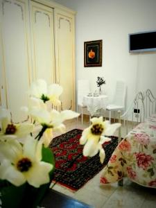 sala de estar con mesa y flores blancas en B&B Main Street, en Reggio Calabria