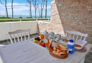 una mesa con una bandeja de comida y una cesta de pan en Pinar del Oriental, en José Ignacio