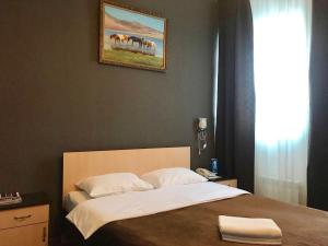 1 cama en un dormitorio con una foto en la pared en Mini-Hotel Pulsar, en Astana