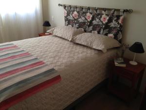 a bedroom with a large bed with a floral headboard at Charme no Centro in Cunha