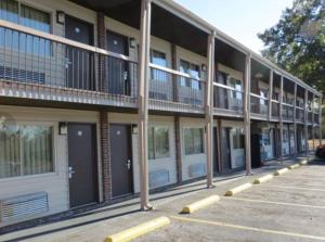 an empty parking lot in front of a building at Redwood Inn in Gadsden