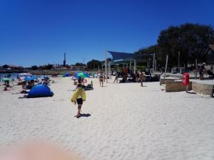 a young child standing on a beach with an umbrella at Sorrento Beach Bed & Breakfast in Perth