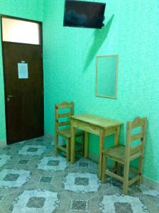 Una mesa y dos sillas en una habitación con puerta en Hostería Don Arturo en Cachí
