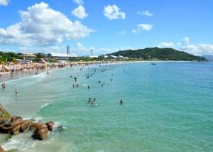 um grupo de pessoas na água em uma praia em Temporada Ponta das Canas em Florianópolis