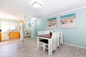 a kitchen and dining room with a table and chairs at Bella Mare Coolangatta Beachside Apartments in Gold Coast