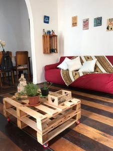 a living room with a red couch and a wooden coffee table at Casarão Banco dos Ingleses 36 in Salvador