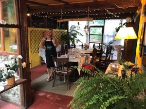 Eine Frau, die vor einem Tisch in einem Restaurant steht. in der Unterkunft El Bambu in Ciudad de la Costa