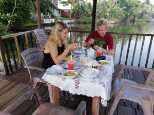 a man and woman sitting at a table eating food at Mahi Villa in Bentota
