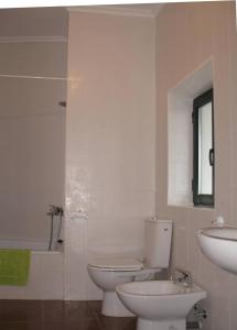 a white bathroom with a toilet and a sink at Casa Rural La Dama del Alba in Vega de Magaz +15 photos