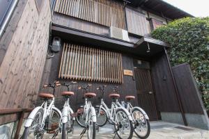 een groep fietsen geparkeerd naast een gebouw bij Guest House Kyorakuya Kinkakuji in Kyoto