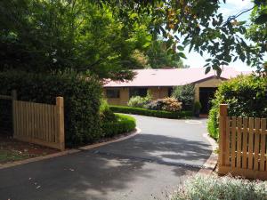 a house with a wooden fence and a driveway at Murrindindi in Kallista