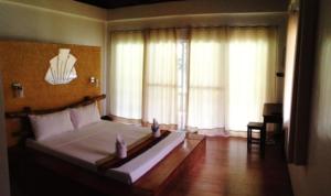 A bed or beds in a room at La Natura Resort