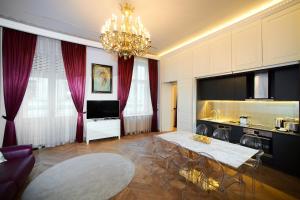 een woonkamer met een eettafel en een kroonluchter bij Count Zrinyi Basilica Luxurious Residence in Boedapest