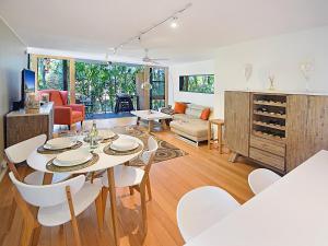 comedor y sala de estar con mesa y sillas en Ludlow, en Noosa Heads