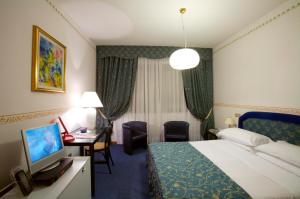 a hotel room with a bed, desk, and television at Hotel Tosco Romagnolo in Bagno di Romagna