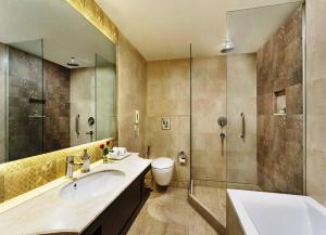 a bathroom with a sink and a shower at La Place Sarovar Portico in Lucknow