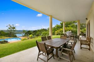 a table and chairs on a patio with a view of the water at Lemon Grove in Montville