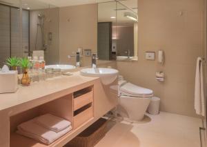 a bathroom with a toilet, sink, and mirror at Hotel COZZI Minsheng Taipei in Taipei
