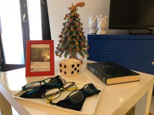 a table with glasses and a christmas tree and a book at Loft P&G in Enna